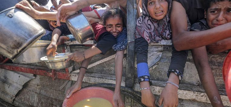 epa12282784 Internally displaced Palestinians, including children, hold pots as they receive food from a charity kitchen, in Gaza City, Gaza Strip, 04 August 2025. Humanitarian organizations have warned of an imminent food catastrophe for thousands of children, a crisis caused by severe food insecurity, a decline in health services, and ongoing restrictions on humanitarian aid and essential supplies.  EPA/MOHAMMED SABER