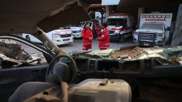 Palestinian paramedics chat near a destroyed ambulance at the headquarters of the Palestinian Red Crescent Society.on February 24,2026 More than a dozen international humanitarian organisations have petitioned Israel's Supreme Court to block an imminent order that would force 37 NGOs to cease operations in Gaza, the West Bank and east Jerusalem, warning of catastrophic consequences for Palestinians.
Bashar Taleb / AFP