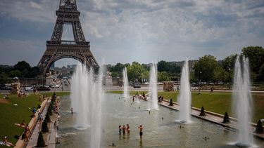 People cool off in the Trocadero Fountain with the Eiffel Tower on the background during a heatwave in Paris on June 26, 2026. 
Dimitar DILKOFF / AFP