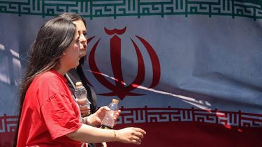 Women walk past Iran's national flag at the Vanak Square in Tehran on June 10, 2026. Iran's foreign ministry said on June 10 that the United States had damaged the ongoing international diplomatic effort to end the war, after more US strikes on targets in southern Iran.
ATTA KENARE / AFP