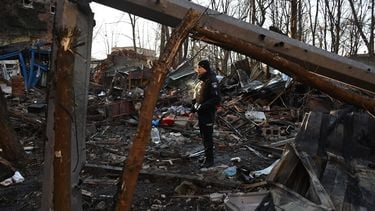A policeman examines the damage outside an apartment building after the overnight Russian drones attack in Kharkiv, December 31, 2023, amid the Russian invasion of Ukraine. Kyiv said on December 31, 2023, it destroyed 21 of 49 Iranian-made 