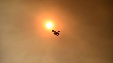 This picture taken on July 26, 2026 shows a firefighting aircraft with the sun in background during a wildfire near Vilavella, 50 kms north of Valencia.  Spanish firefighters today battled a new front of fires near the coastal city of Valencia, where at least 15,000 people were evacuated. Spain has already evacuated tens of thousands of people from villages west of the capital Madrid where extremely dry conditions have been worsened by heatwaves and strong winds. In the Valencia region, on Spain's eastern coast, authorities said they were struggling to contain fires.
Jose JORDAN / AFP