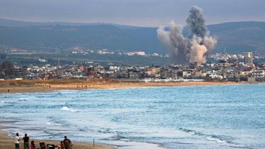 People visit beach against the backdrop of smoke rising from the site of an Israeli strike near the southern Lebanese city of Tyre on May 27, 2026. Israel launched broad strikes on Lebanon including near the city of Tyre on May 27, as Hezbollah said its fighters clashed with Israeli forces beyond an Israeli-declared 
