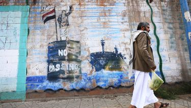 epa13232230 A person walks past the shuttered Saudi embassy with a graffitied wall depicting a Houthi fighter stopping a ship off the coast of Yemen, in Sana'a, Yemen, 11 September 2026.  Yemen's Houthi group said navigation in the Red Sea and Bab el-Mandeb Strait remained safe except for Saudi vessels, which it says remain subject to a blockade, after seizing the port city of Mocha on 10 September and making further gains around the strategic strait on 11 September.  EPA/YAHYA ARHAB
