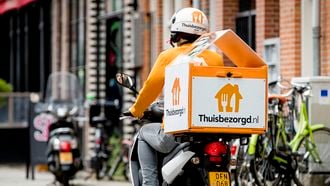 Een bezorger van Thuisbezorgd.nl verwerkt een bestelling. De maaltijdbezorging maakt de laatste jaren een grote groei door. Niet alleen neemt het aantal maaltijdbezorgers toe, er is ook een duidelijke verschuiving te zien in leeftijd. De bezorgers worden steeds jonger, ziet de inspectie.