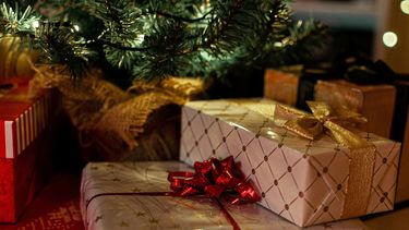 Een foto van cadeautjes onder de kerstboom.
