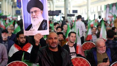 epa12749895 An Iranian man holds a picture of Iranian supreme leader Ayatollah Ali Khamenei during a memorial ceremony for those killed in anti-government protests earlier last month, at the Mosallah mosque in Tehran, Iran, 17 February 2026. Following US military threats against Iran, Iranian supreme leader Ayatollah Ali Khamenei said on 17 February 2026, that the US and its president could not destroy Iran, adding that the 'strongest military force in the world may at times be struck so hard that it cannot get up again'.  EPA/ABEDIN TAHERKENAREH