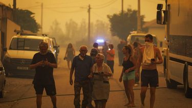 epa13140520 People walk in a street during a wildfire that started in Valpacos and is now raging in the villages of Fradizela, Mirandela municipality, Portugal, 29 July 2026.  EPA/PEDRO SARMENTO COSTA