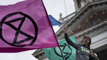 An activist from the climate change action group Extinction Rebellion holds a flag during a protest at the Place Royale in Brussels on October 12, 2019.   
 
Kenzo TRIBOUILLARD / AFP