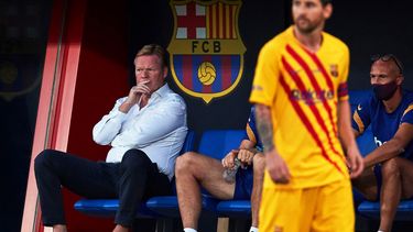 Op deze foto is Ronald Koeman te zien, tijdens een wedstrijd van Barcelona. Op de voorgrond is Messi te zien.