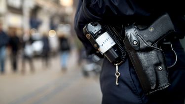Op deze foto is de uitrusting van een politieagent te zien: pepperspray en een dienstwapen.