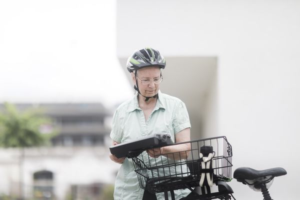 Op deze foto zie je een ouder persoon op een e-bike