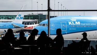 SCHIPHOL - Passagiers zitten in Lounge 1, het winkel- en horecagebied na de veiligheidscontrole op luchthaven Schiphol, met op de achtergrond vliegtuigen van KLM. Vanuit deze terminal vertrekken de meeste Europese (vakantie)vluchten. ANP RAMON VAN FLYMEN