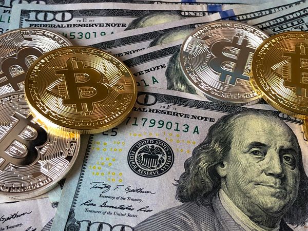 Een foto van cash geld en bitcoin door elkaar