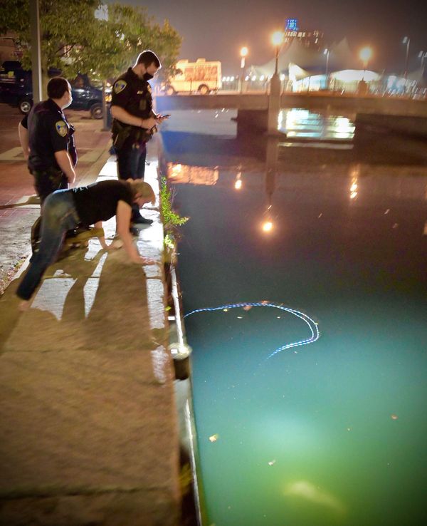 Een foto van agenten die naar het water kijken