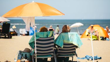 mensen genieten op het strand van warme zomer