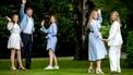 Een foto van de leden van het koninklijk huis, zwaaiend in hun tuin