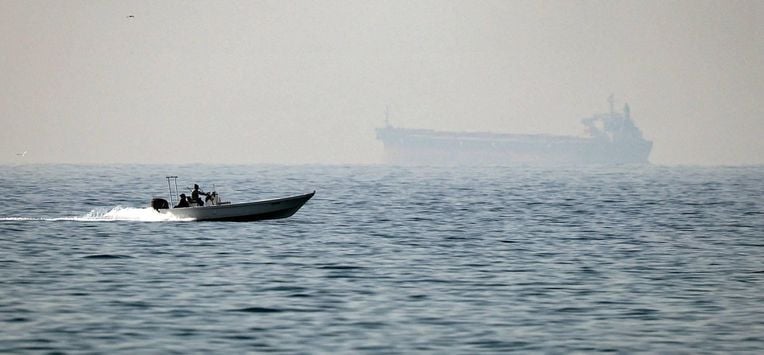 (FILES) A motorboat cruises along the shore off the town of Al Jeer on the Strait of Hormuz in the northern emirate of Ras Al Khaimah, with a tanker seen in the background, on February 25, 2026.
 The US president sent a peace plan to Iran as he voiced optimism on March 25, 2026 at ending nearly a month of warfare, with Tehran announcing that it will let 