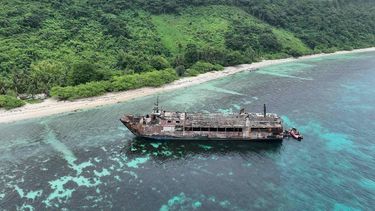 This handout photo taken on September 11, 2026 and released by the Philippine coast Guard (PCG), shows an aerial shot of the ill-fated M/V June Aster with coast guard boats (R) at the stern off the shores of Coron town, Palawan province.  The deadly blaze that swept through a Philippine ferry happened 