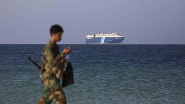 epa11012877 A Houthi soldier walks through the beach with the Galaxy Leader cargo ship in the background, seized by the Houthis offshore of the Al-Salif port on the Red Sea in the province of Hodeidah, Yemen, 05 December 2023. The Galaxy Leader ship, reportedly linked to an Israeli businessman, was seized and re-routed to offshore of the Yemeni port of Al-Salif by the Houthis on 19 November 2023 in retaliation for Israel's airstrikes on the Gaza Strip, according to statements by the Houthis. The ship, carrying around 25 crew members belonging to various nations, was seized as it was on its way to India. The Houthis, who control most of Yemen 's Red Sea coast, have fired missiles and drones at Israel and attacked more vessels transiting the area. Thousands of Israelis and Palestinians have died since the militant group Hamas launched an unprecedented attack on Israel from the Gaza Strip on 07 October, and the Israeli strikes on the Palestinian enclave which followed it.  EPA/YAHYA ARHAB