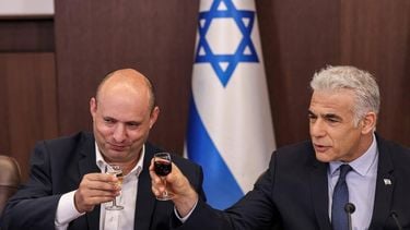 epa10191085 Israel's caretaker Prime Minister Yair Lapid (R) and former prime minister Naftali Bennett toast with small glasses of wine during the weekly cabinet meeting in Jerusalem, 18 September 2022.  EPA/RONALDO SCHEMIDT / POOL