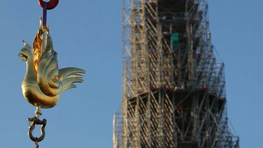 The new golden rooster containing relics is lifted by crane to be installed atop the spire of Notre Dame cathedral as part of its reconstruction, in central Paris on December 16, 2023.  The golden rooster, designed by architect Philippe Villeneuve, contains relics saved from the fire that struck the monument on April 15, 2019, and a document with the names of those working on its reconstruction.
Thomas SAMSON / AFP