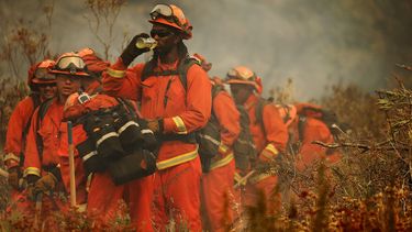 Op deze foto zie je brandweer proberen de natuurbrand genaam 'Apple Fire' vlakbij Beaumont /Californië