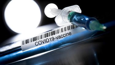 Een foto van een mogelijk coronavaccin en een injectiespuit