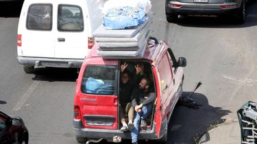 A woman flashes the V-sign as she rides in the back of a van laden with mattresses, as civilians flee their homes and head north toward the Lebanese capital, hours after a military escalation that included Israeli airstrikes targeting the south on April 26, 2026. Hezbollah rejected Israel's prime minister's accusation that it was jeopardising a ceasefire and said it would continue responding to Israel's violations and its occupation of south Lebanon on April 26. Lebanon was drawn into the Middle East war on March 2, 2026, when the Tehran-backed militant group Hezbollah launched attacks on Israel to avenge the killing of the Iranian leader. Israel has responded with broad strikes across Lebanon and a ground offensive.
MAHMOUD ZAYYAT / AFP