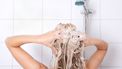Een foto van een vrouw onder de douche, bezig met haar wassen