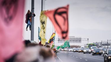 AMSTERDAM - Demonstranten van Extinction Rebellion tijdens een blokkade van de snelweg A10 bij het voormalig ING-hoofdkantoor op de Zuidas. Ze eisen dat de bank stopt met alle financiering van, en dienstverlening aan de fossiele industrie. ANP PHIL NIJHUIS
