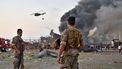 Op deze foto zie je twee Libanese soldaten kijken naar hoe eenhelikopter bezig is de brand te blussen welke ontstaan is door de explosie