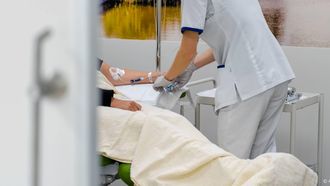 ILLUSTRATIEF - Een medewerker helpt een patient op de afdeling oncologie van het Haaglanden Medisch Centrum Antoniushove. ANP MARCO DE SWART kanker hersenen onderzoek vasten kanker intermittent fasting