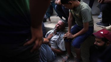 Palestinians gather around a man mourning outside the Al-Shifa hospital in Gaza City on July 31, 2025, where bodies of people killed a day earlier while waiting for aid were brought. Gaza's civil defence agency said Israeli forces killed at least 30 people when they opened fire on July 30 on a crowd waiting for humanitarian aid in the north of the Palestinian territory.
BASHAR TALEB / AFP