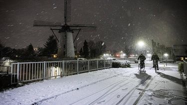 GELDROP - Fietsers trotseren de sneeuw. In het zuiden van het land is het aan het eind van de middag begonnen met sneeuwen. ANP ROB ENGELAAR
