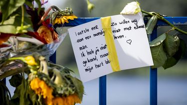 Op deze foto zijn bloemen en een kaart te zien bij het recreatiegebied waar Bas van Wijk werd doodgeschoten.