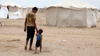 epa13246536 A displaced man and his brother walk through a makeshift camp for Internally Displaced Persons (IDPs) in the southern port city of Aden, Yemen, 17 September 2026. At least 125,000 Yemenis have been displaced over the past two weeks amid the country’s renewed fighting between Houthi forces and Saudi-backed government forces, according to the UN Office for the Coordination of Humanitarian Affairs (OCHA).  EPA/NAJEEB MOHAMED