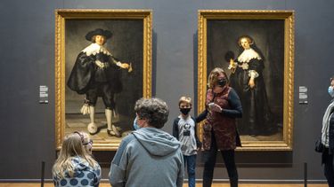 Op deze foto zijn mensen in het Rijksmuseum te zien, ze hebben mondkapjes op.