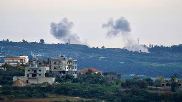 This photograph taken on January 5, 2024 from the southern Lebanese village of Dhayra along the Israeli border, shows buildings in the Lebanese town of Tair Harfa as smoke billows over northern Israel, amid ongoing cross-border tensions as fighting continues between Israel and Hamas militants in the Gaza Strip. 
AFP
