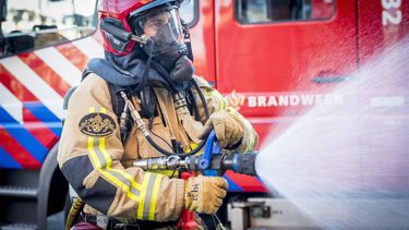 AMSTERDAM - Een brandweerman tijdens bluswerkzaamheden. ANP XTRA LEX VAN LIESHOUT