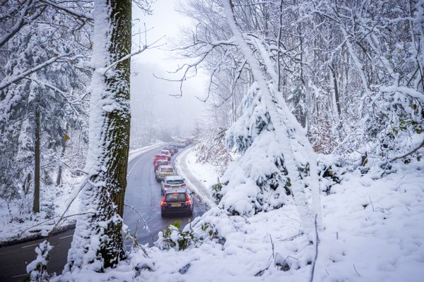 Sneeuw bij Drielandenpunt, auto's staan in de file.