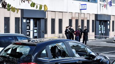 Op deze foto is het politiebureau in Parijs te zien, er staat een auto met ingeslagen ramen.