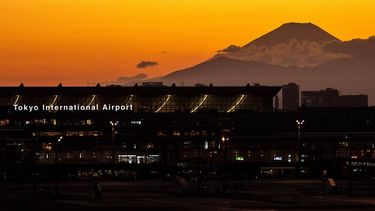 A general view shows the terminal building of Haneda Airport with Mount Fuji (back-R) from the airport's observation deck in Tokyo on February 28, 2023. 
Philip FONG / AFP
