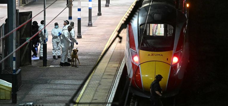 Police officers and a dog handler work on the platform alongside an LNER Azuma train at Huntingdon Station in Huntingdon, eastern England, on November 1, 2025, following a stabbing on a train.  UK police said they had arrested two suspects Saturday as 