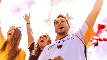 Een foto van juichende voetbalsupporters, in Deutschland shirt