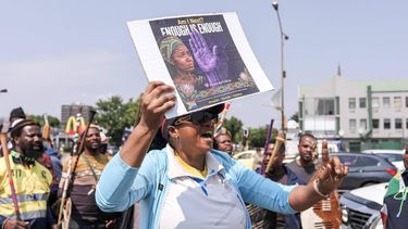 A woman holds a placard as she takes part with others during a protest march in Kempton Park on September 19, 2026 following the recent string of murders that occurred in the east of Johannesburg.  South African police on September 17 recovered the body of a ninth woman east of Johannesburg in two months, as a string of murders continues to stoke public anxiety. The country has one of the world's highest homicide rates but the discovery of the women's bodies, partially naked and battered, has raised fears that a serial killer or group of killers may be operating in the area. Police have offered a 400,000 rand ($25,000) reward for any information that could lead to the arrest of the killer or killers, while the Democratic Alliance, the second largest political party in South Africa offered $31,000.
MZINGENKOSI SIBANDA / AFP