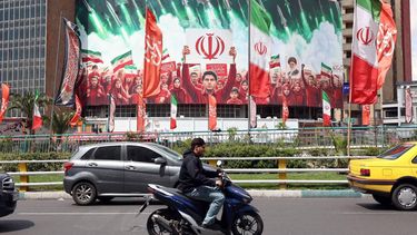 epa12871324 Iranians drive past a large political billboard displaying Iran's national flags at Valiasr Square in Tehran, Iran, 06 April 2026. The US president has given Iran a 48-hour deadline to reach a deal and reopen the Strait of Hormuz.  EPA/ABEDIN TAHERKENAREH