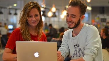 Een foto van twee MOOV studenten achter een laptop