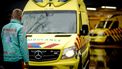 Op deze foto is een ambulancebroeder te zien die op een ambulancebus afloopt.