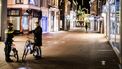 Een foto van een agent en een fietser tijdens de avondklok